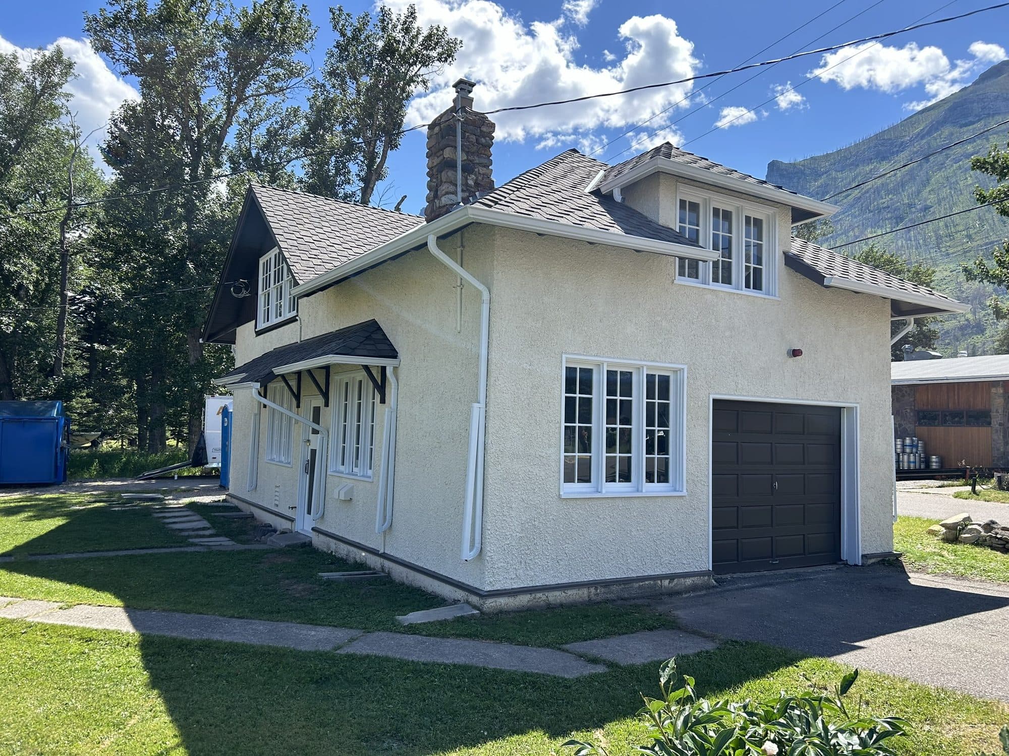 A home and attached garage finished in cream stucco, a First Class Stucco & Masonry job